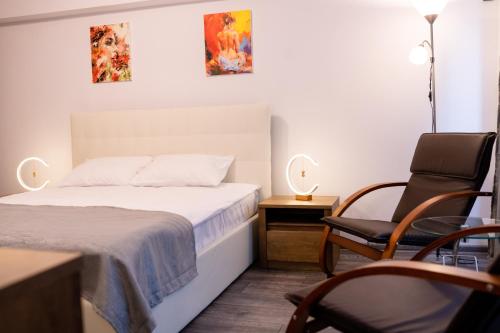 1 dormitorio pequeño con 1 cama y 1 silla en Apartament ALESSIA, en Drobeta-Turnu Severin