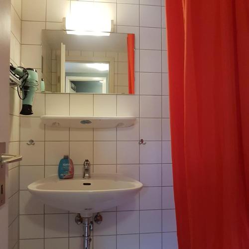 a bathroom with a sink and a mirror at Stadtnah an der Förde 104 in Flensburg