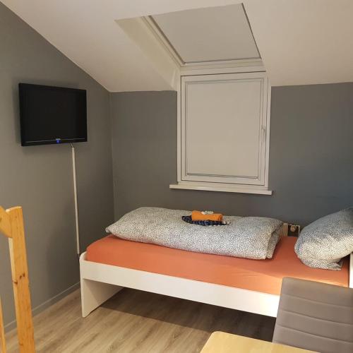 1 dormitorio con 1 cama, ventana y TV en Stadtnah an der Förde 104, en Flensburg