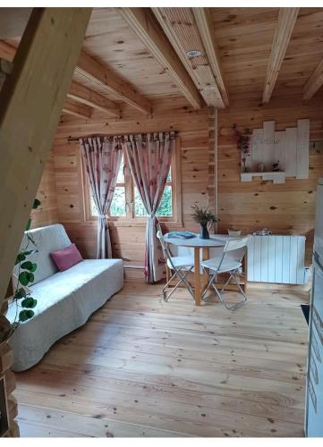 - un salon avec un canapé et une table dans une cabine dans l'établissement L'orée des bois , détente et calme ., à Mésigny
