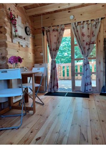 une pièce avec une table et une grande fenêtre dans l'établissement L'orée des bois , détente et calme ., à Mésigny