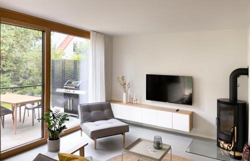 a living room with a television and a chair and a table at Haus Meerling in Rerik