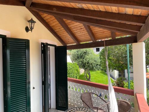 a patio with chairs and a wooden pergola at Cosy 2 bedroom home in the heart of Jardim do Mar in Jardim do Mar
