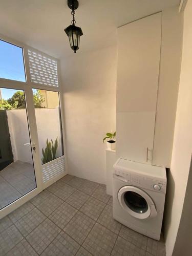 a washing machine in a room with a window at Cosy 2 bedroom home in the heart of Jardim do Mar in Jardim do Mar