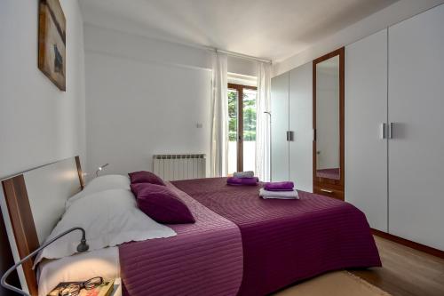 ein Schlafzimmer mit einem lila Bett mit lila Kissen in der Unterkunft Apartman Grabar in Roč