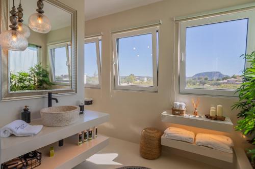 a bathroom with a sink and two windows at Villa Shangri-La Zakinthos in Zakynthos Town
