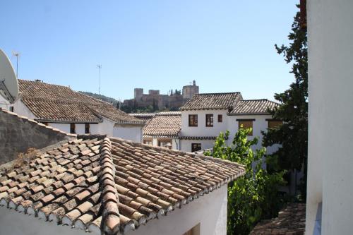 a view of roofs of houses with a castle in the background at Oripando Hostel in Granada