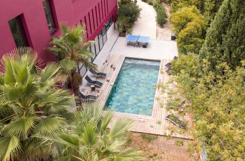 - une vue sur la piscine située à côté d'un bâtiment dans l'établissement VILLA MAGNOLIA, à Montpellier