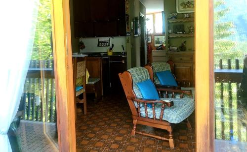 View-stunning 2 BR apartment in the heart of Alps في سيلا نيفيا: غرفة معيشة مع كرسيين ومطبخ