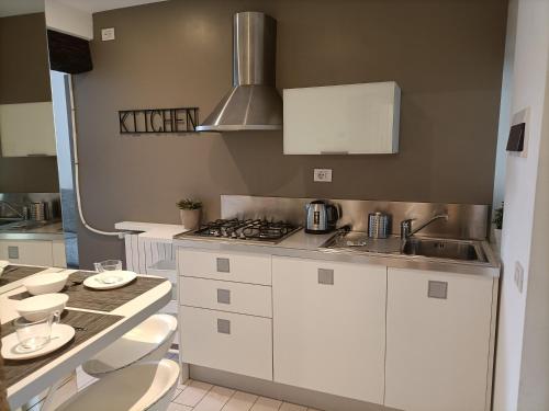 a kitchen with white cabinets and a sink at BE MY GUEST charme e relax in citta' alta in Bergamo