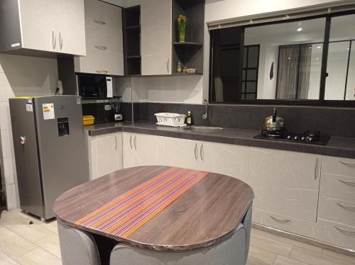 a kitchen with a wooden table and a refrigerator at La Casa de Justi in Huancayo