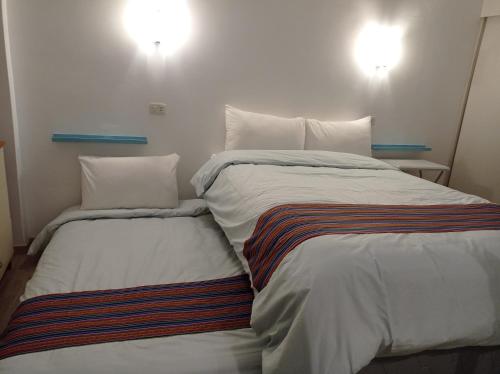 two beds sitting next to each other in a room at La Casa de Justi in Huancayo