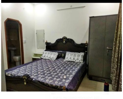 una camera con letto in legno e 2 cuscini di Shiv Gauri Home Stay a Rishikesh