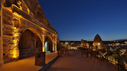 a building with an archway with tables and chairs at night at Elite Cave Suites in Goreme
