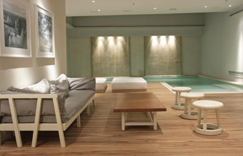 Habitación con piscina, sofá y mesa en Libertad Hotel Buenos Aires, en Buenos Aires
