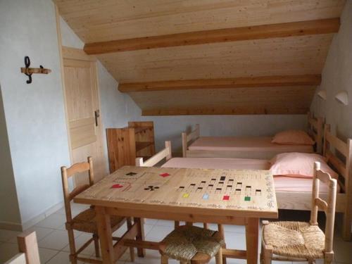 um quarto com uma mesa de madeira e uma cama em GITE LES 1000 FLEURS em Souteyros