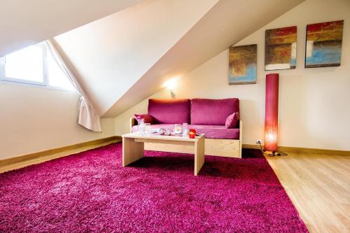 a living room with a pink couch and a pink rug at Hotel Arha Mar Comillas in Comillas