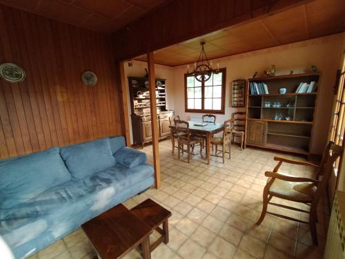 uma sala de estar com um sofá azul e uma mesa em Les Chaumes em Villiers-en-Morvan