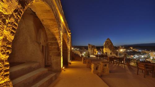 a building with stairs and tables and chairs at night at Elite Cave Suites in Goreme