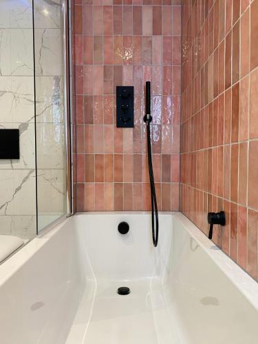 a bath tub with a shower in a bathroom at Sebastians in Oswestry