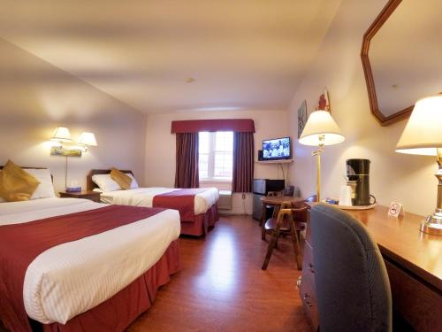 ein Hotelzimmer mit 2 Betten und einem Schreibtisch in der Unterkunft Sherwood Inn and Motel Charlottetown in Charlottetown