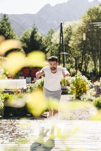 a man running through a puddle of water at Traumhotel Alpina Superior Adults only Hotel in Gerlos