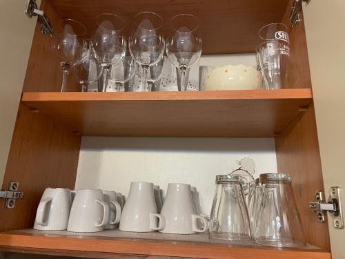 un placard rempli de verres à vin dans l'établissement Apartament Stanca Piticului, à Sinaia