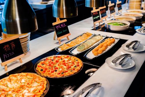 a buffet with pizzas and different types of food at Crowne Plaza Shenzhen Nanshan by IHG in Shenzhen