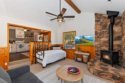a living room with a fireplace and a couch and a stove at DoorMat Vacation Rentals - Brother Bear Cabin with free WIFI! in Big Bear City