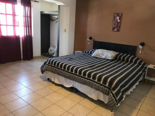 1 dormitorio con 1 cama con edredón blanco y negro en Departamento Belgrano III en Salta