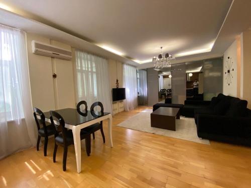 ドニプロにあるАпартаменты в центре Днепраのリビングルーム(テーブル、黒いソファ付)