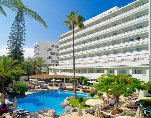 a view of a hotel with a pool and palm trees at Boutique Hotel H10 Big Sur - Adults Only in Los Cristianos