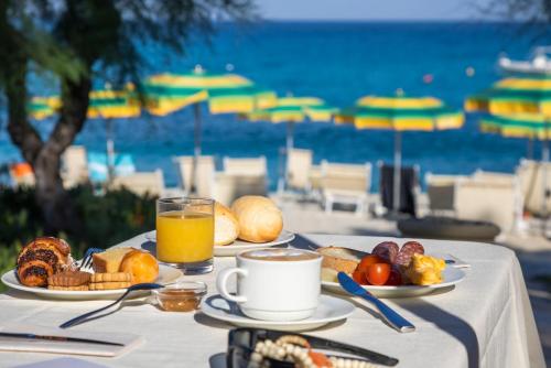 a table with a breakfast of coffee and croissants and orange juice at Villaggio Il Gabbiano in Capo Vaticano