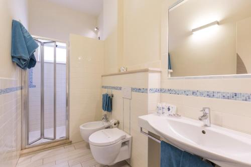 a bathroom with a toilet and a sink and a mirror at Villaggio Il Gabbiano in Capo Vaticano