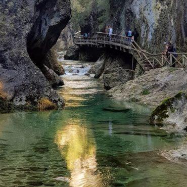 a painting of people crossing a bridge over a river at Hotel Tharsis in Cazorla