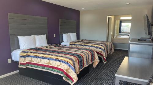 ヒューストンにあるExecutive Inn and Suites Houstonのベッド2台とテレビが備わるホテルルームです。