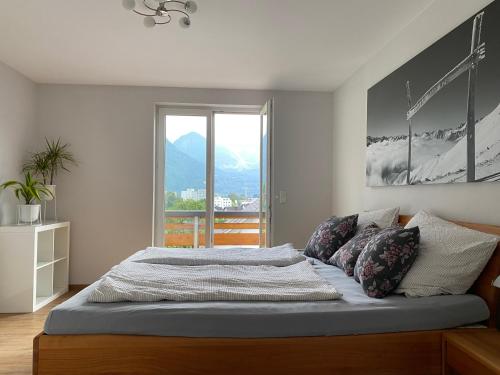 a bedroom with a large bed with a large window at Appartement Schillerkopf in Bludenz