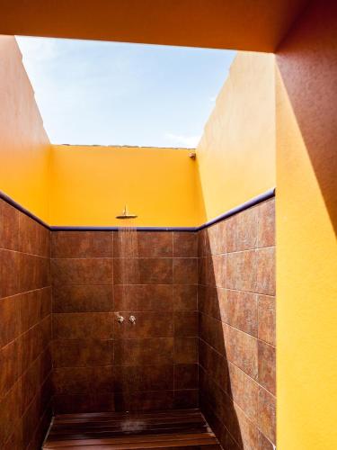 a bathroom with a shower with a yellow ceiling at Monte da Esperanca in Esperança