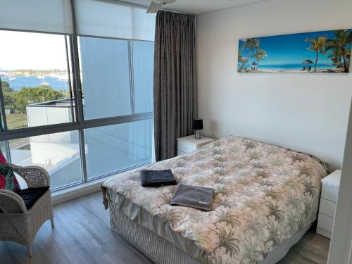 a bedroom with a bed and a large window at Marina ocean view at The Shores in Gold Coast