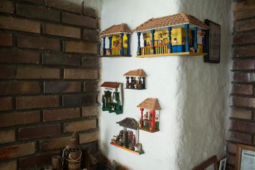 a wall with three wooden toy houses on it at La Cigarra Casa de Huéspedes in Salento