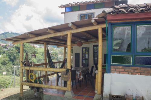 a wooden pergola on the side of a house at La Cigarra Casa de Huéspedes in Salento