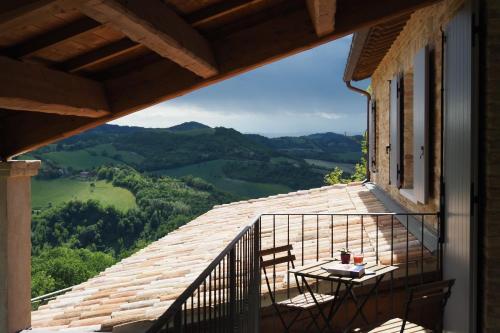 a balcony with a table and chairs on a roof at Country House Ca'Balsomino in Urbino