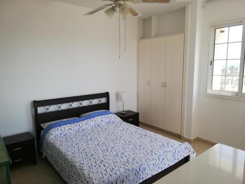 a white bedroom with a bed and a window at Ria Beach Sea View Apartment in Pyla