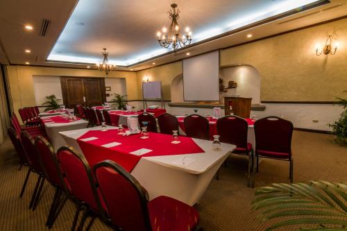 a conference room with a long table with red tables and chairs at Hotel Soleil La Antigua in Antigua Guatemala