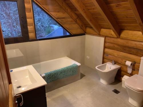 e bagno con vasca, servizi igienici e lavandino. di Casa Lago Hermoso a San Martín de los Andes