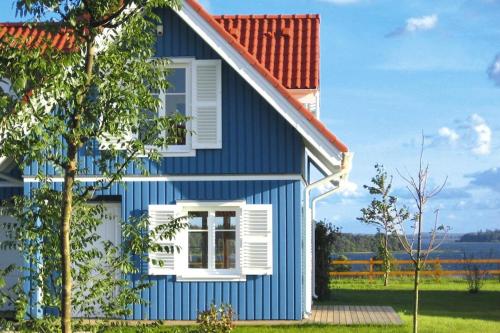 a blue and white house with a window at Holiday village Mamry directly on the lake in Trygort in Trygort