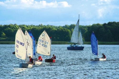 a group of people in small sailboats on a lake at Holiday village Mamry directly on the lake in Trygort in Trygort