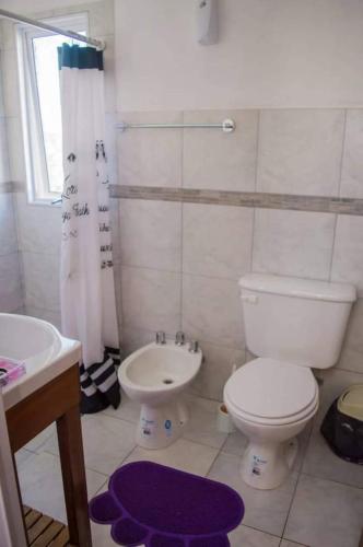 a white bathroom with a toilet and a sink at LA MARTINA APART HOTEL in San Ignacio