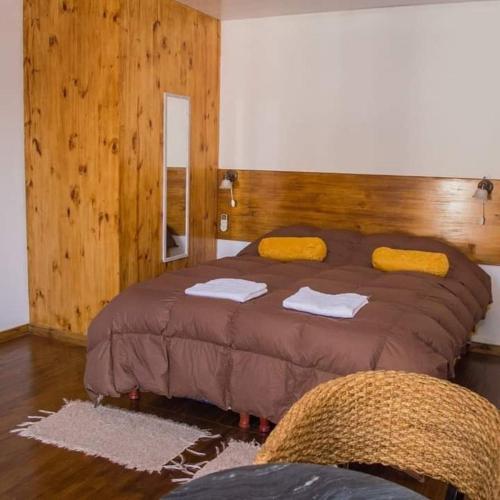 a bedroom with a large bed with yellow towels on it at LA MARTINA APART HOTEL in San Ignacio