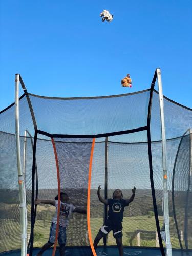 two people are playing on a trampoline at Milton Woodstock Homestead Luxury retreat with NEW 11M POOL just minutes from the beach in Milton